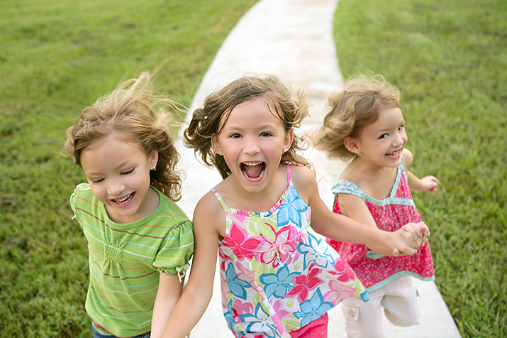 Smiling Young Girls Running On Sidewalk
